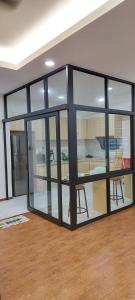 Miri Sunsky Condominium Homestay 3 Rooms & 6 Guest في ميري: غرفة معيشة بأبواب زجاجية وطاولة