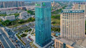 een luchtzicht op een hoog glazen gebouw in een stad bij Holiday Inn Changchun Oriental Plaza, an IHG Hotel in Changchun