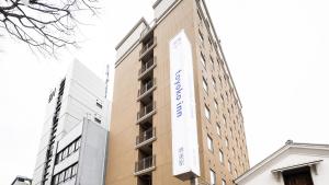 堺市Toyoko Inn Osaka Sakai-higashi-eki的建筑的侧面有标志