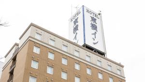 堺市Toyoko Inn Osaka Sakai-higashi-eki的上面有大标志的建筑