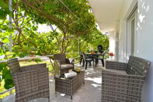 een patio met rieten stoelen en een tafel op een veranda bij Apartments Mala Vala 925 - adapted in Fažana