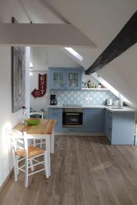 a kitchen with blue cabinets and a wooden table and chairs at Ferienwohnung Luna in Trier