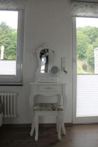 a white dressing table with a mirror and a chair at Ferienwohnung Luna in Trier