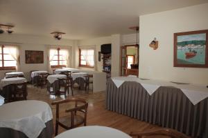 une salle à manger avec des tables, des chaises et un tissu de table blanc dans l'établissement Pramataris, à Monemvasia