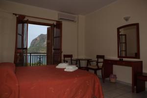 - une chambre avec un lit et un balcon avec vue dans l'établissement Pramataris, à Monemvasia