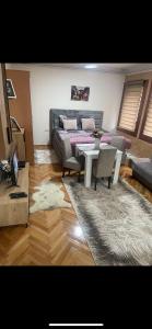 um quarto com uma cama, uma mesa e cadeiras em ALOHA apartment em Novi Pazar