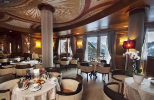 un restaurante con mesas y sillas y techo en Cristal Palace Hotel, en Madonna di Campiglio