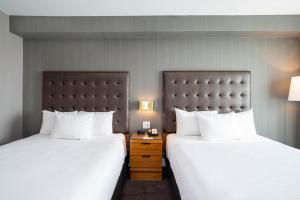 A bed or beds in a room at Sandman Hotel Hamilton