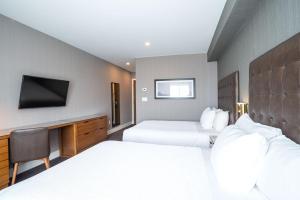 A bed or beds in a room at Sandman Hotel Hamilton