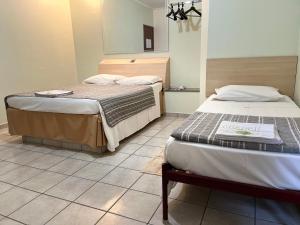 Zimmer mit 2 Betten und Fliesenboden in der Unterkunft Hotel Taquaral in Campinas