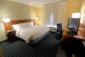 Fairfield Inn & Suites by Marriott Bowling Green في بولينغ غرين: غرفة فندقية فيها سرير ومكتب وتلفزيون