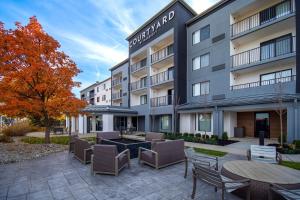 einen Blick nach außen auf ein Hotel mit Tischen und Stühlen in der Unterkunft Courtyard by Marriott Cincinnati Airport in Erlanger