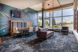 eine Lobby mit einem Sofa, einem Tisch und Stühlen in der Unterkunft Four Points by Sheraton Lévis Convention Centre in Lévis