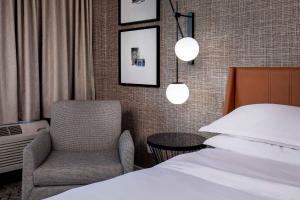 - une chambre avec un lit, une chaise et deux lumières dans l'établissement Sheraton Pentagon City, à Arlington