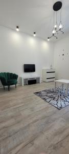 uma sala de estar com um sofá e uma televisão na parede em Apartament CityStation em Wałbrzych