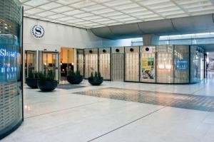 Sheraton Paris Charles de Gaulle Airport Hotel في رواسي أون فرانس: لوبي مبنى فيه نباتات الفخار