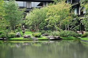 un jardin avec un étang en face d'un bâtiment dans l'établissement HOTEL THE MITSUI KYOTO, a Luxury Collection Hotel & Spa, à Kyoto