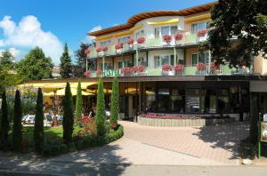 un edificio alberghiero con molti fiori e piante di Parkhotel an der Therme a Bad Krozingen