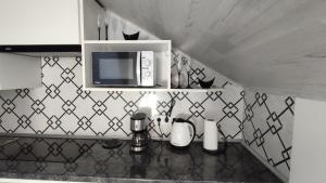 a kitchen with a counter top with a microwave at Апартаменти - Історія з вікна in Kamianets-Podilskyi