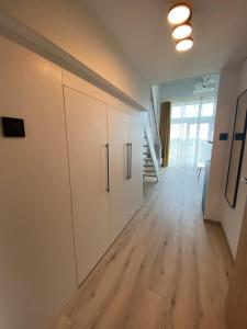 弗罗茨瓦夫Apartament Wrocław-Lotnisko的一间空房间,配有白色橱柜和木地板