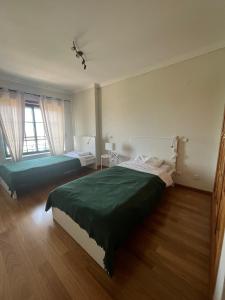 - une chambre avec 2 lits et une grande fenêtre dans l'établissement HigH Cascais, à Cascais