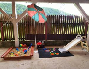 een kinderspeelplaats met een parasol en een speeltuin bij Bunloc House in Braşov