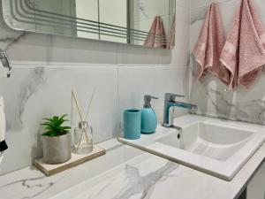 Baño blanco con lavabo y espejo en AVRORA, en Varna