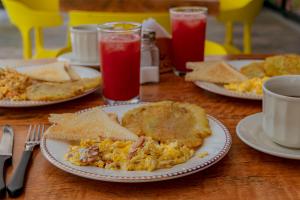 un tavolo con piatti di uova, pane tostato e bevande di Hotel Marco Polo Rodadero a Santa Marta