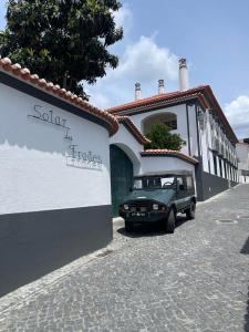 a green jeep parked in front of a building at SOLAR DOS FRADES in Ferreira do Alentejo