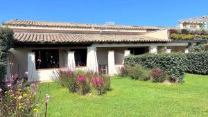 una casa con un jardín con flores delante en ISS Travel, San Teodoro 1 - 100 m from Cala d'Ambra Beach, en San Teodoro