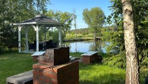 una mesa de picnic con un cenador junto a un lago en Mazurskie Siedlisko Langen, en Mrągowo