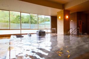 uma piscina de água num quarto com janelas em Ooedo Onsen Monogatari Hotel Kinugawa Gyoen em Nikko