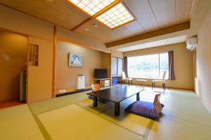 uma sala de estar com uma mesa e uma janela em Ooedo Onsen Monogatari Hotel Kinugawa Gyoen em Nikko