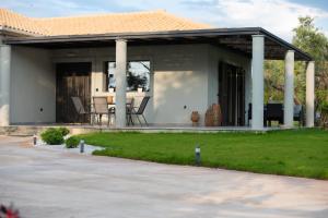 a home with a covered porch with a table at Aerinos private villa in Lefkada Town