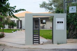 a cat is sitting next to a small house at Aerinos private villa in Lefkada Town