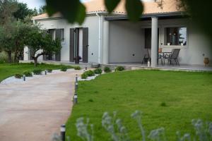 a house with a green lawn in front of it at Aerinos private villa in Lefkada Town