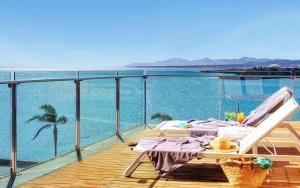 een terras met een tafel en een stoel op het water bij Arrecife Gran Hotel & Spa in Arrecife