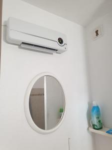 uno specchio a muro accanto al bagno di Appartement vacances cap d’agde a Cap d'Agde