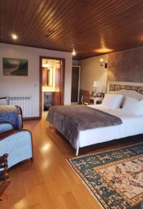 a large bedroom with a large bed and a chair at Casa De Canilhas in Mesão Frio