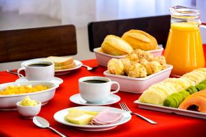 una mesa cubierta con platos de comida y tazas de café en Hotel Fazenda Aguas de Lindoia, en Águas de Lindóia