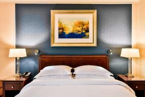 1 dormitorio con 1 cama con una pintura en la pared en Sheraton Skyline Hotel London Heathrow, en Hillingdon