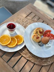 uma mesa com dois pratos de comida e um ovo e fatias de laranja em Hotel Senator em Ulcinj