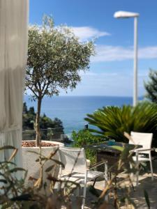 vista para o oceano a partir de um pátio com cadeiras em Hotel Senator em Ulcinj