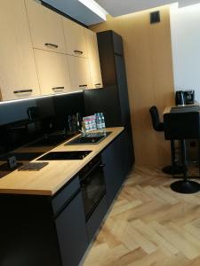 eine Küche mit schwarzen Schränken und einer Arbeitsplatte in der Unterkunft Business Apartment Płock in Płock