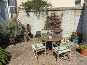 um pátio com uma mesa e cadeiras num quintal em Cliffside em Cowes