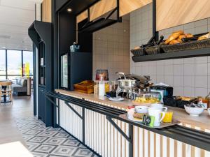 a kitchen with a counter with food on it at B&B HOTEL Sélestat Centre-Alsace in Sélestat