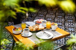 een tafel met borden met eten en drinken bij Rugendas Hotel Boutique by Time Hotel & Apartments in Santiago