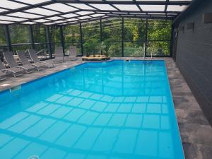 a large swimming pool with blue water at Domaine de la Résidence - Hôtel, Spa & Restaurant in Moulins-lès-Metz