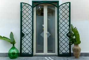 una porta d'ingresso con un vetro e un telaio in ferro battuto di Casa Corallium a Torre del Greco