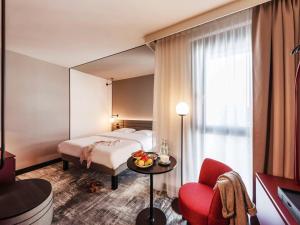 ミュンスターにあるNovotel Münster Cityのベッドと鏡が備わるホテルルーム